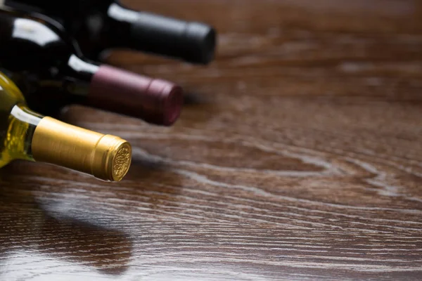 Diverse Wijnflessen Een Reflecterend Houtoppervlak Kort — Stockfoto