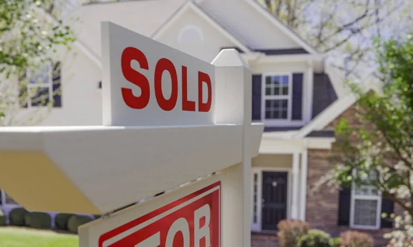 Close-up of Sold Placard On House For Sale Real Estate Sign In Front of New House.