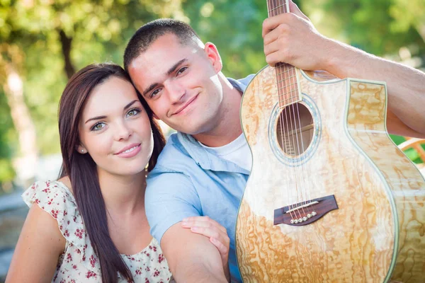 公園でギターと若い大人のカップルの肖像画 — ストック写真