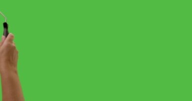 Female Hand Using Paint Roller To Cover Entire Green Screen.