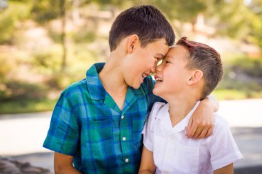 Outdoor portrait of mixed race Chinese and Caucasian brothers having fun.