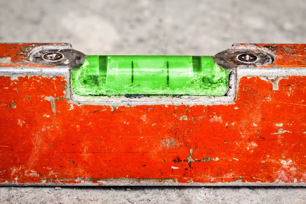 Used and dirty spirit level on a concrete wall — Stock Photo, Image