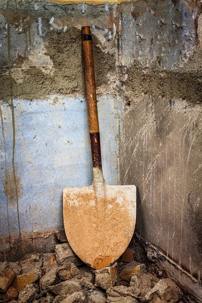 Eski bir duvarın köşesinde kirli küreği — Stok fotoğraf