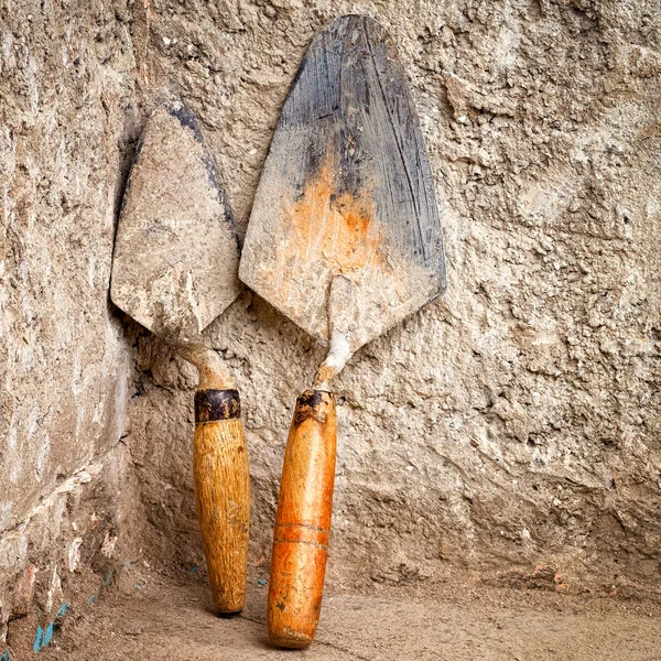 Trowels on a rough concrte wall — Stock Photo, Image