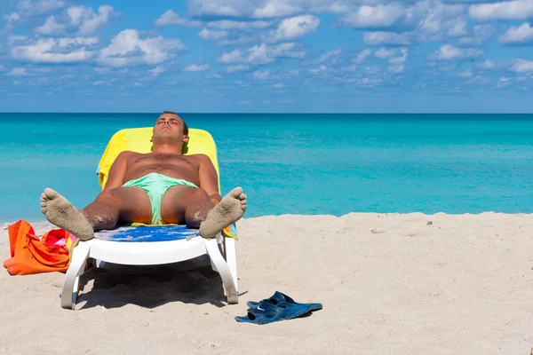 Junger mann sonnt sich am strand von varadero in kuba — Stockfoto