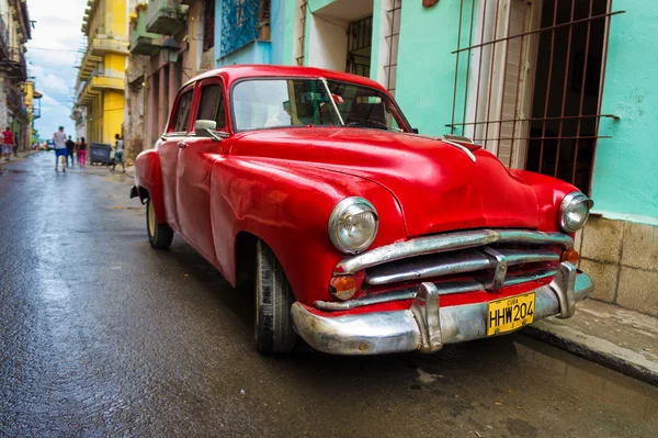 Oude rode auto in een sjofel straat in havana — Stockfoto