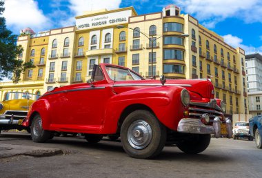 Vintage red Ford parked near a hotel in Havana clipart