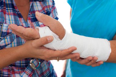 Woman with a broken arm and her caregiver clipart