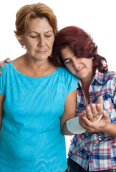 Mujer anciana con un brazo roto y su cuidador — Foto de Stock