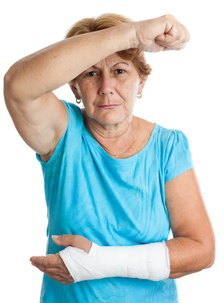 Ηλικιωμένη γυναίκα με ένα σπασμένο βραχίονα υπερασπίζεται τον ευατό της κατά ένα ΑΓΓ — Φωτογραφία Αρχείου
