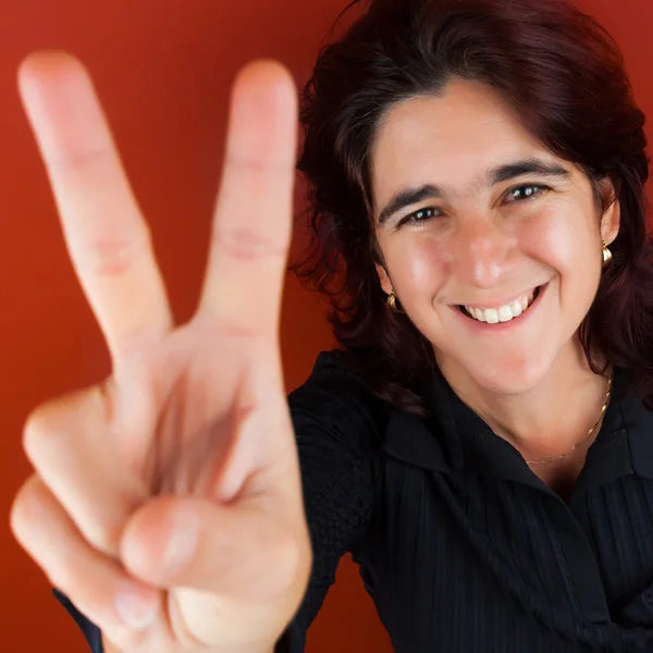 Hispánský žena, která dělá znamení vítězství — Stock fotografie