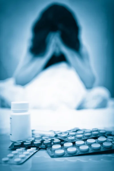 Píldoras y fuera de foco mujer enferma o deprimida —  Fotos de Stock