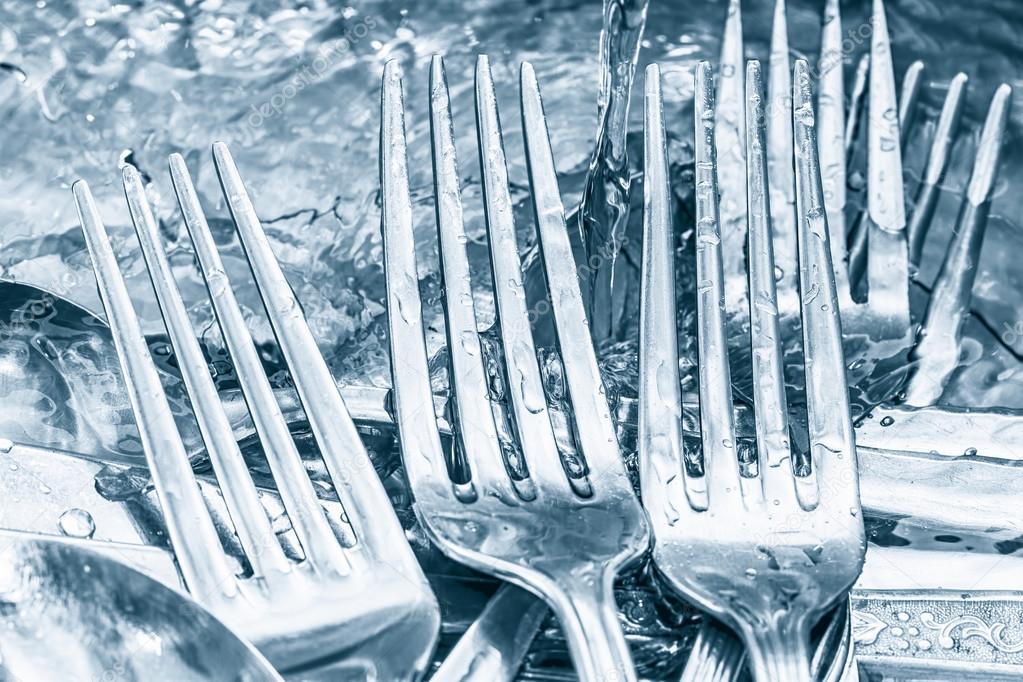 Blue toned silverware being washed with water Stock Photo by ©kmiragaya