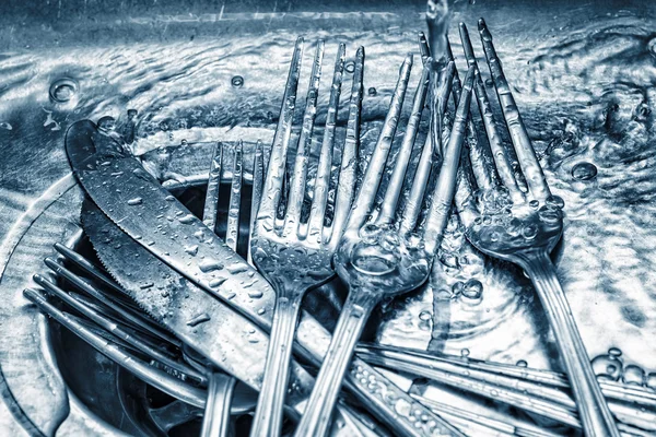 Forks and knives washed on a kitchen sink — Stock Photo, Image