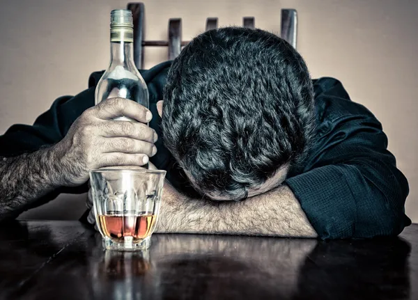 Homme ivre dormant la tête sur une table — Photo