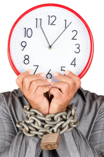 Homem segurando um relógio no lugar de seu rosto com as mãos acorrentadas — Fotografia de Stock