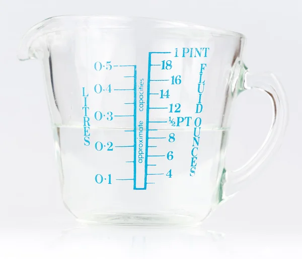 Measuring cup containing water — Stock Photo, Image