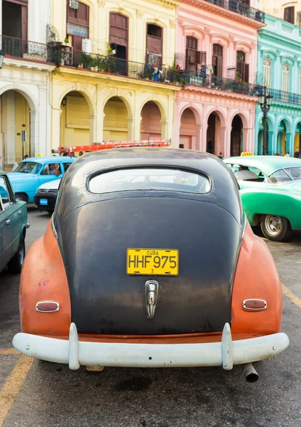 Oude auto geparkeerd in de buurt van kleurrijke gebouwen in havana — Stockfoto