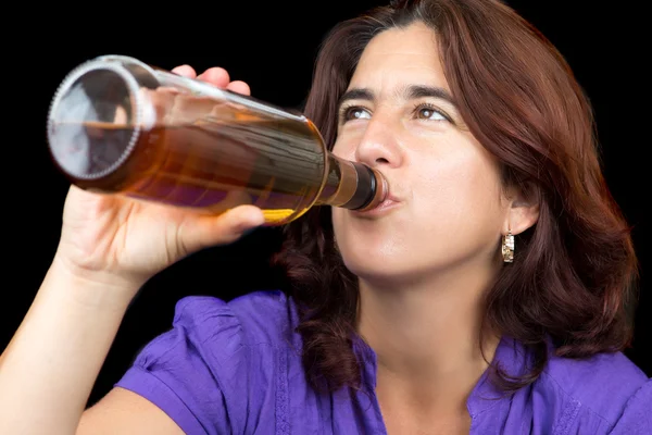 Femme hispanique buvant dans une bouteille de whisky ou de rhum — Photo