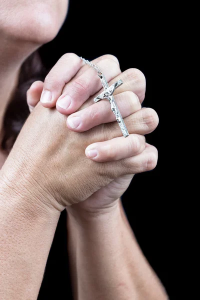 Mãos rezando e segurando um pequeno crucifixo — Fotografia de Stock