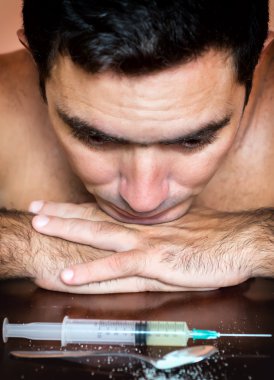 Addict with the cravings looking at drugs