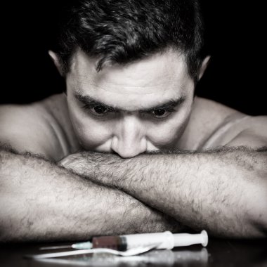 Depressed drug addict and a syringe clipart