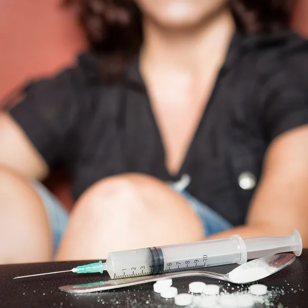 Syringe and female drug addict — Stock Photo, Image