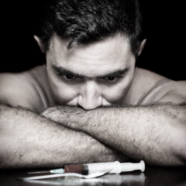 Depressed drug addict and a syringe