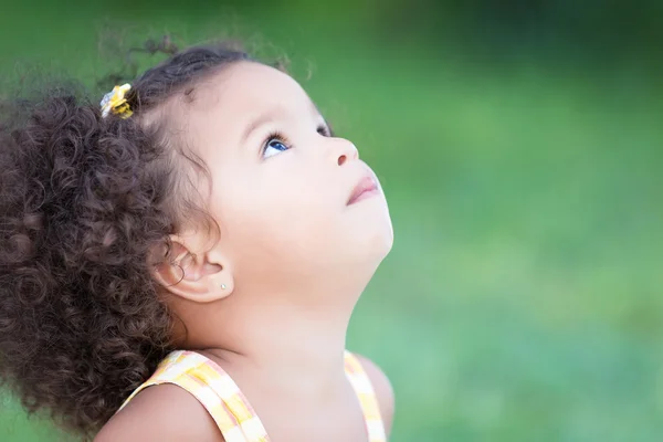 Hispanic girl with an afro hairstyle looking up — Stock Photo, Image