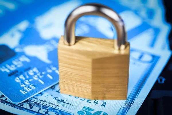 Closed padlock over a stack of money and cards — Stock Photo, Image