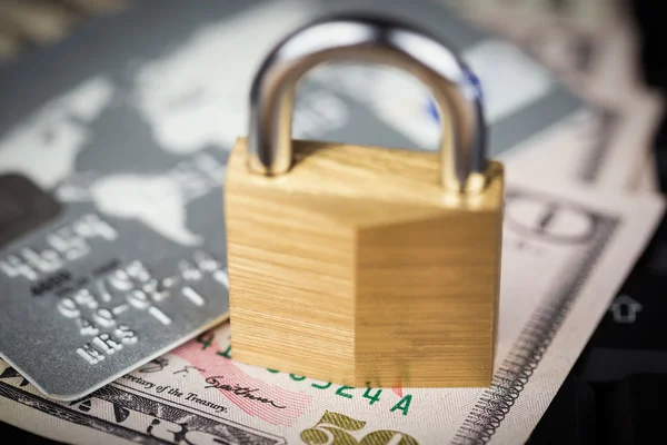 Closed padlock over a stack of money and cards — Stock Photo, Image