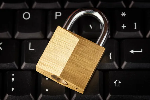 Candado cerrado en un teclado de ordenador negro — Foto de Stock