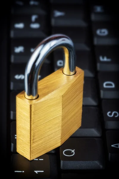 Candado cerrado en un teclado de ordenador negro — Foto de Stock