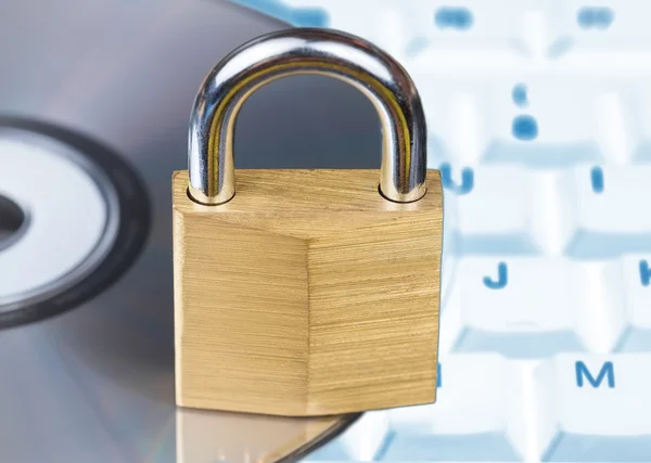 Closed padlock, keyboard and DVD - data security — Stock Photo, Image