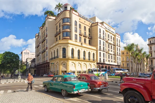 Carros americanos antigos perto de um hotel moderno em Havana — Fotografia de Stock