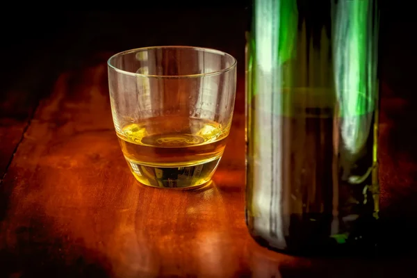 Whisky or rum and a green liquor bottle — Stock Photo, Image