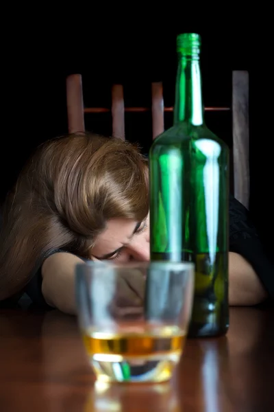Drunk alcoholic woman sleeping on a table — Stock Photo, Image