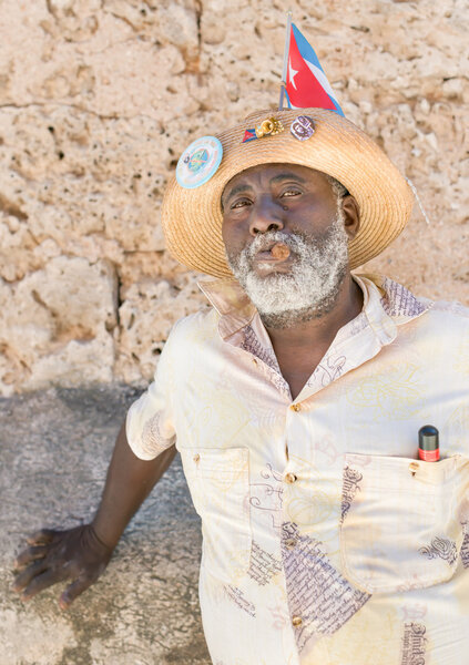 Чёрный человек курит кубинскую сигару в Старой Гаване
