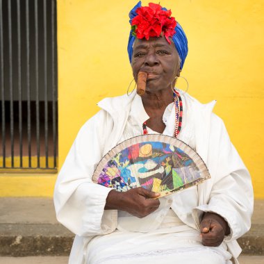 Old black lady smoking a cuban cigar in Havana clipart