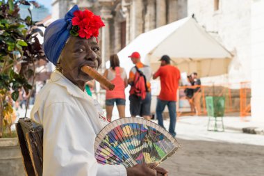 Old black lady smoking a cuban cigar in Havana clipart