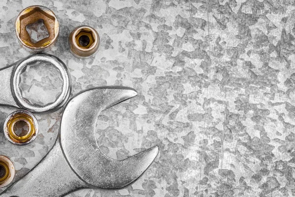 Wrench tools and nuts on a metallic background — Stock Photo, Image