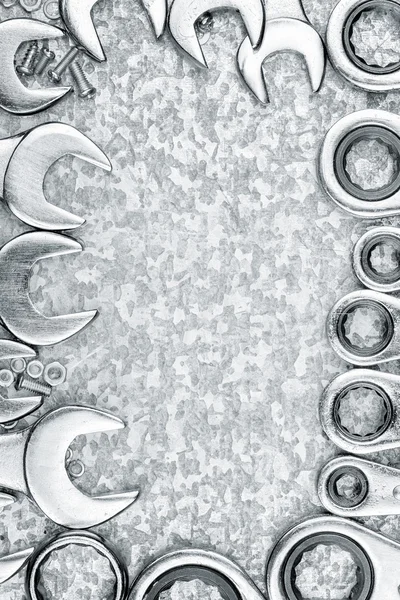 Schraubenschlüssel und Werkzeuge umrahmen einen metallischen Hintergrund — Stockfoto