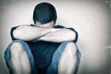 yere ağlama üzerinde oturan üzgün youg adam