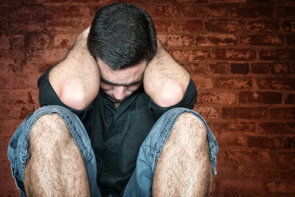 Jovem estressado e triste sentado no chão — Fotografia de Stock