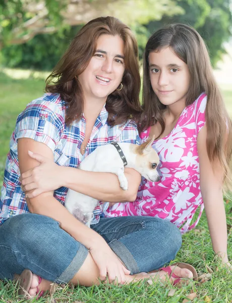 Família hispânica com seu pequeno cão em um parque — Fotografia de Stock