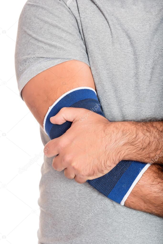 Man with a therapeutic elastic band on his elbow