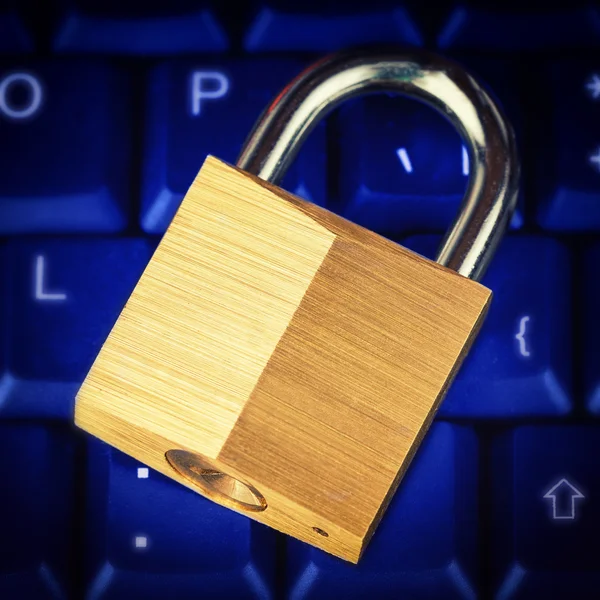 Gyllene cosed metalliska lösenord över en blå upplyst tangentbord — Stockfoto