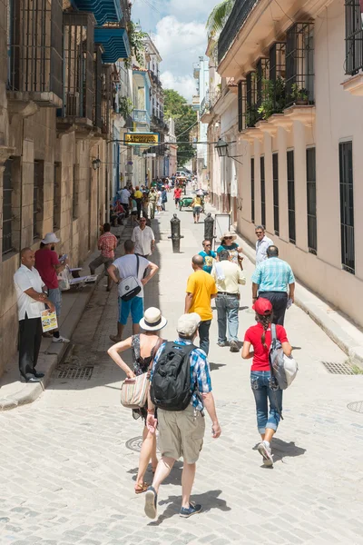 Turistas e locais em uma típica rua colorida em Havana — Fotografia de Stock