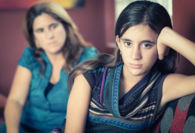 Defiant teenage girl and her worried mother clipart