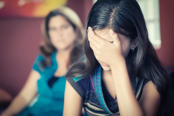 Teenage girl cries with her mother on the background — Stock Photo, Image